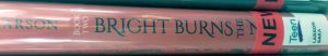 A book spine, with the end of the title obscured by stickers. The author is Larson, and the spine reads 'Book Two: Bright Burns the N-'